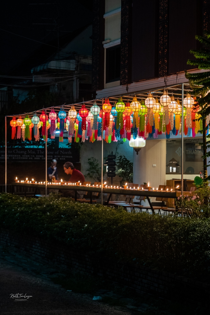 A diner enjoys the lamp light while he eats outside during the Loy Krathong celebrations.