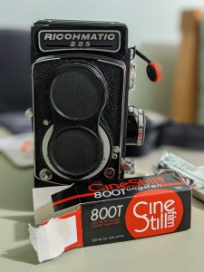 A photo of my Ricohmatic 225 and some Cinestill 800T film all ready to shoot