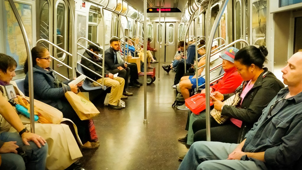 A photo taken on the subway in New York featuring a carriage full of people