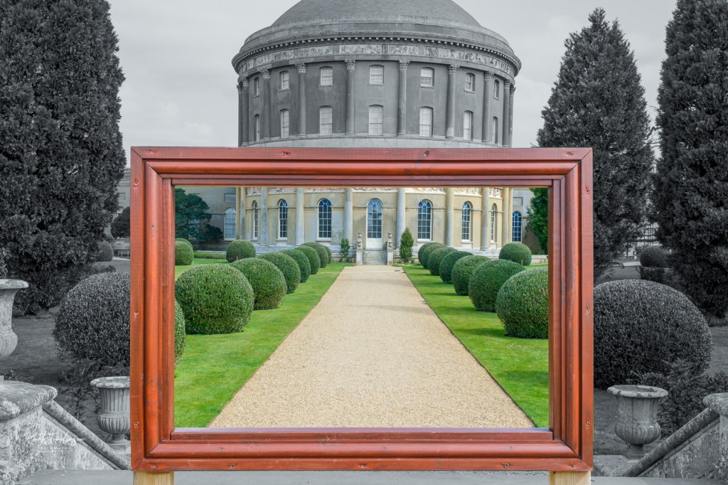 A view of Ickworth house through a wooden picture frame, the outside is in black and white and the view within is in full colour.