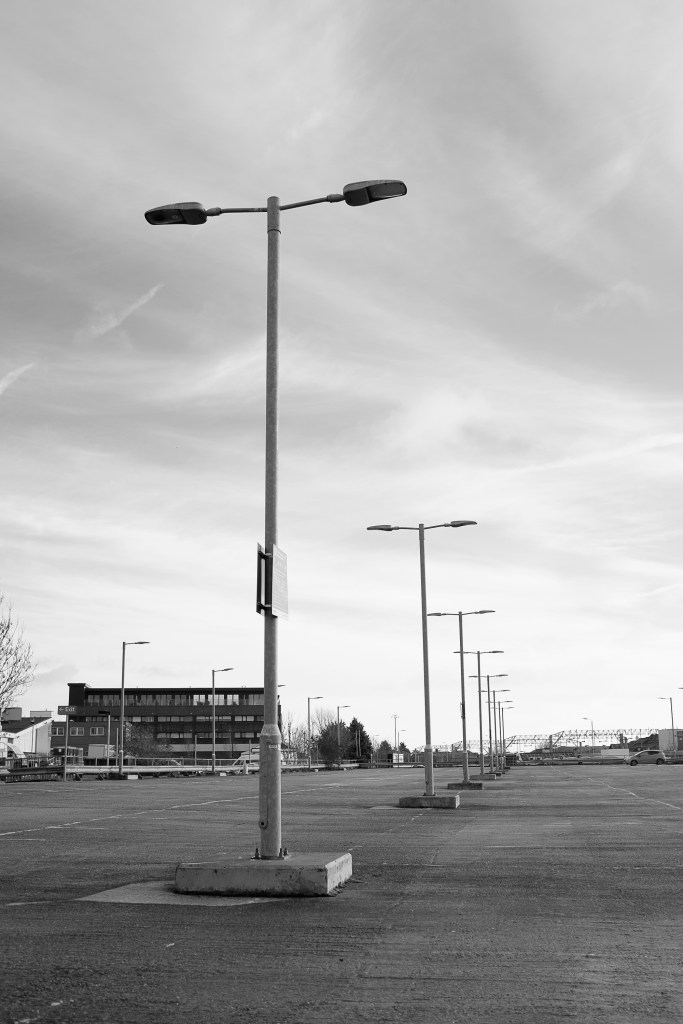 A row of lampposts stand in a row and off into the distance