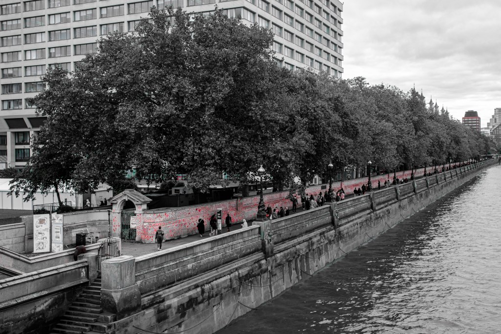 A wall is covered in red hearts painted on by the public to represent those lost to Covid 19.