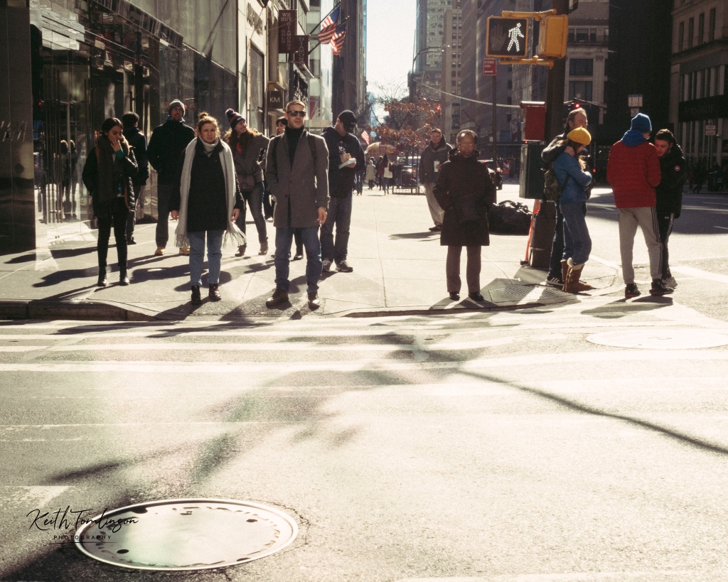 A group of people wait to cross the street in New York