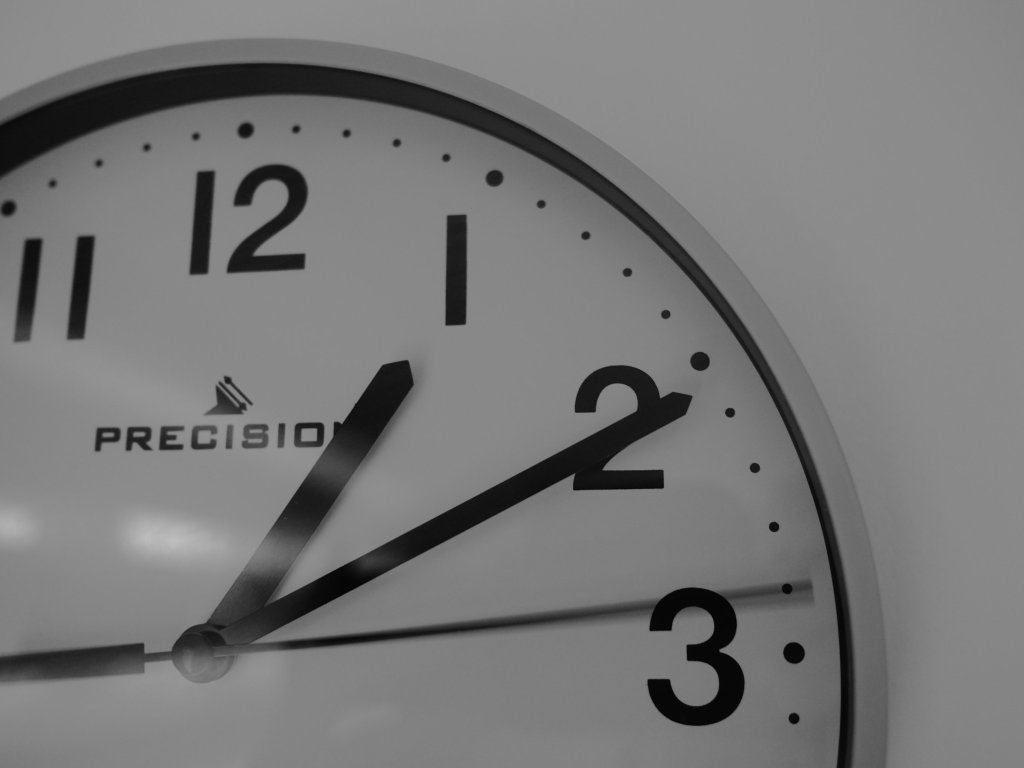 A clock second hand moves around the face at ten past one 
