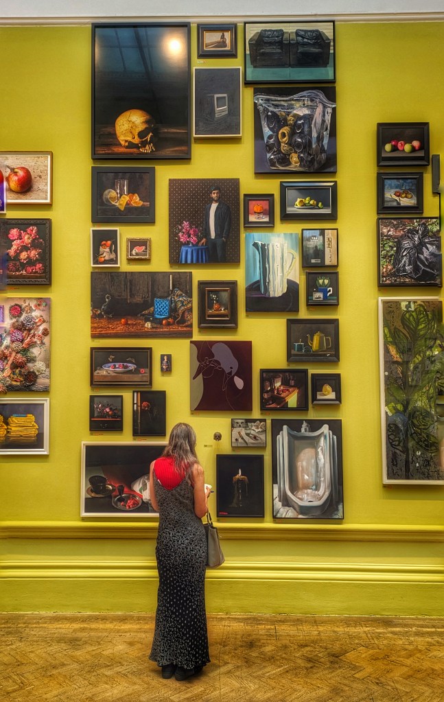 A lady studies art on a yellow all
